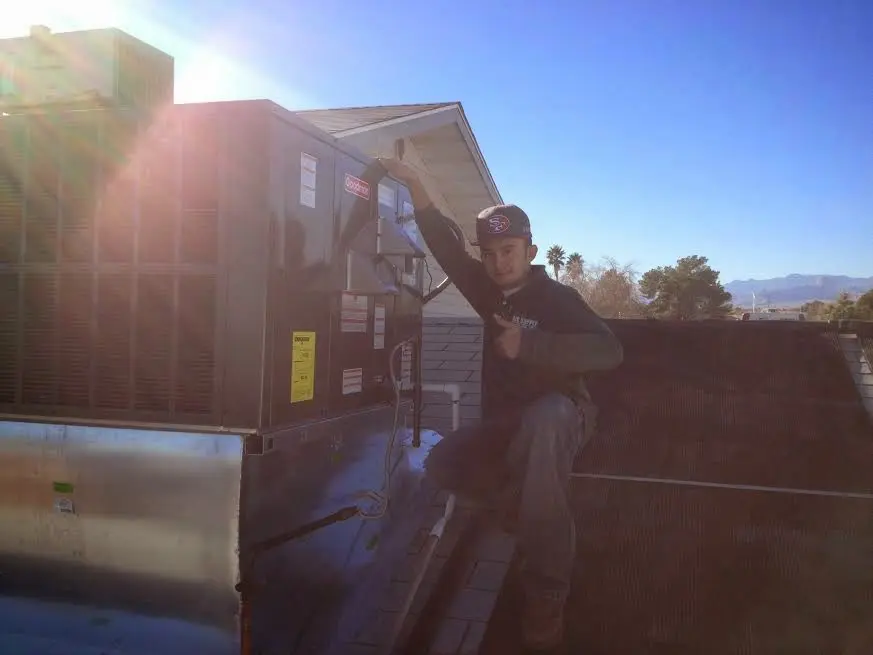 HVAC technician performing HVAC Inspection on a rooftop unit in Rockland